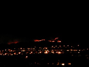 wildfires at night seen beyond lights of the city in the faraway hills