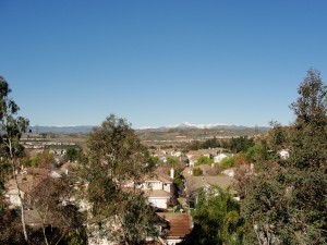 view over rooftops of snowy mountains in distance