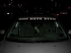 "move over" printed in mirror image on windshield of car