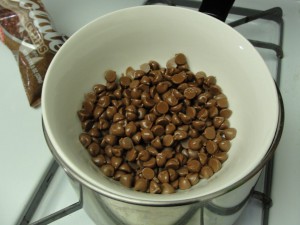 melting the milk chocolate morsels in a bowl in a pot
