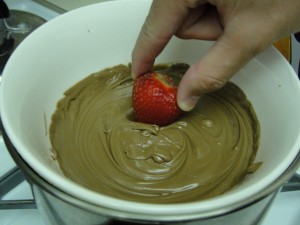 dipping strawberry into melted chocolate