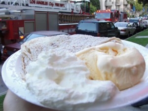 a plate of crepes, ice cream, and whipped cream with a fire truck in the background
