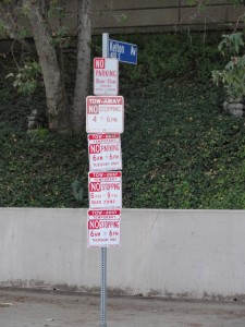 five separate parking signs restricting parking on gayley ave