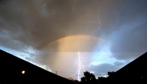 lightning appearing under rainbow