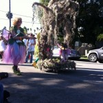 dog dressed as fairy hanging on a mossy tree float for haute dog parade 2010