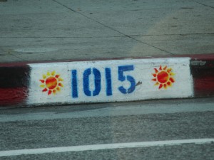 bright sun design painted on curb next to street number