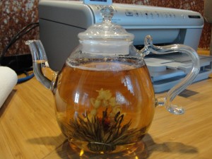 glass teapot with blossoming tea inside