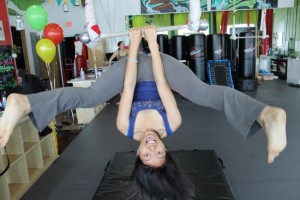 hanging upside down from trapeze, with legs spread wide