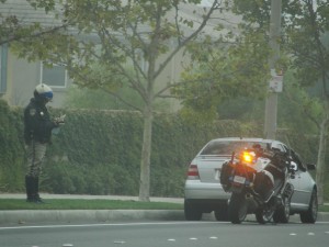 motorcycle cop pulls over a car
