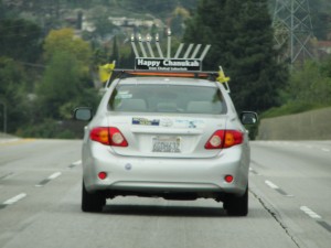 a spirited display of hanukkah candles atop a car on the freeway