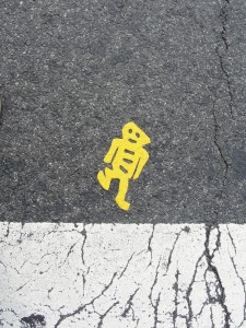 yellow image of robot man imprinted on sidewalk