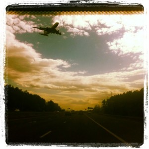 large plane landing as shot from interior of car, photo edited with instagram
