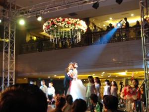 the bride and groom share a kiss as they are elevated by a platform