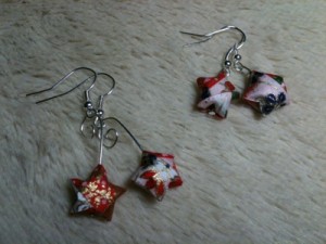 two pairs of star-shaped origami earrings made with red, white, cream, blue, green, brown, and gold japanese design