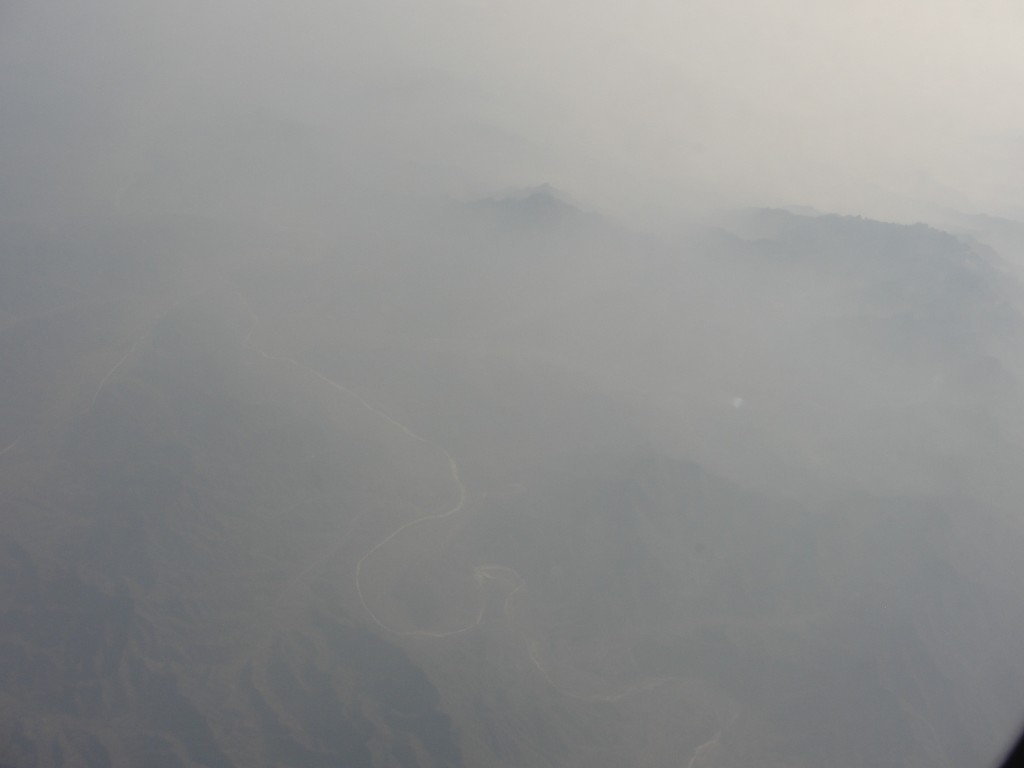 hazy view of ground below from airplane