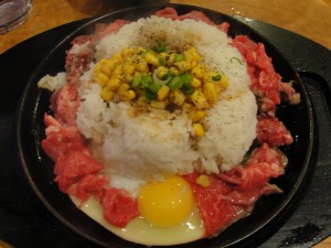 pepper lunch beef with rice, corn, and egg on sizzling platter