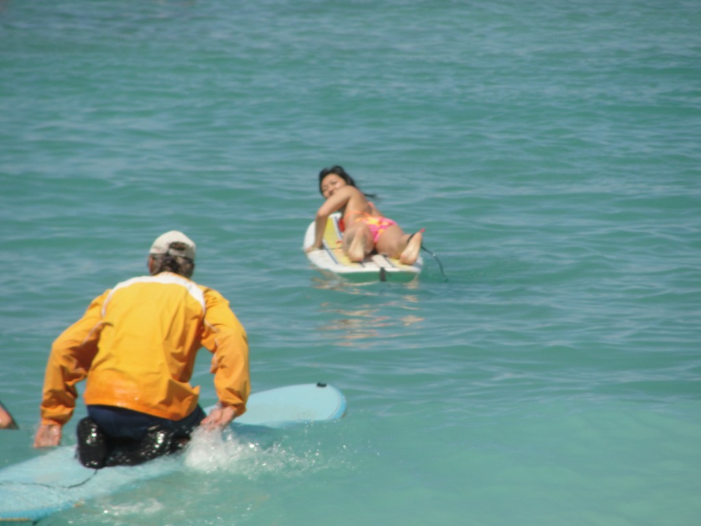 laying on surfboard paddling out into ocean