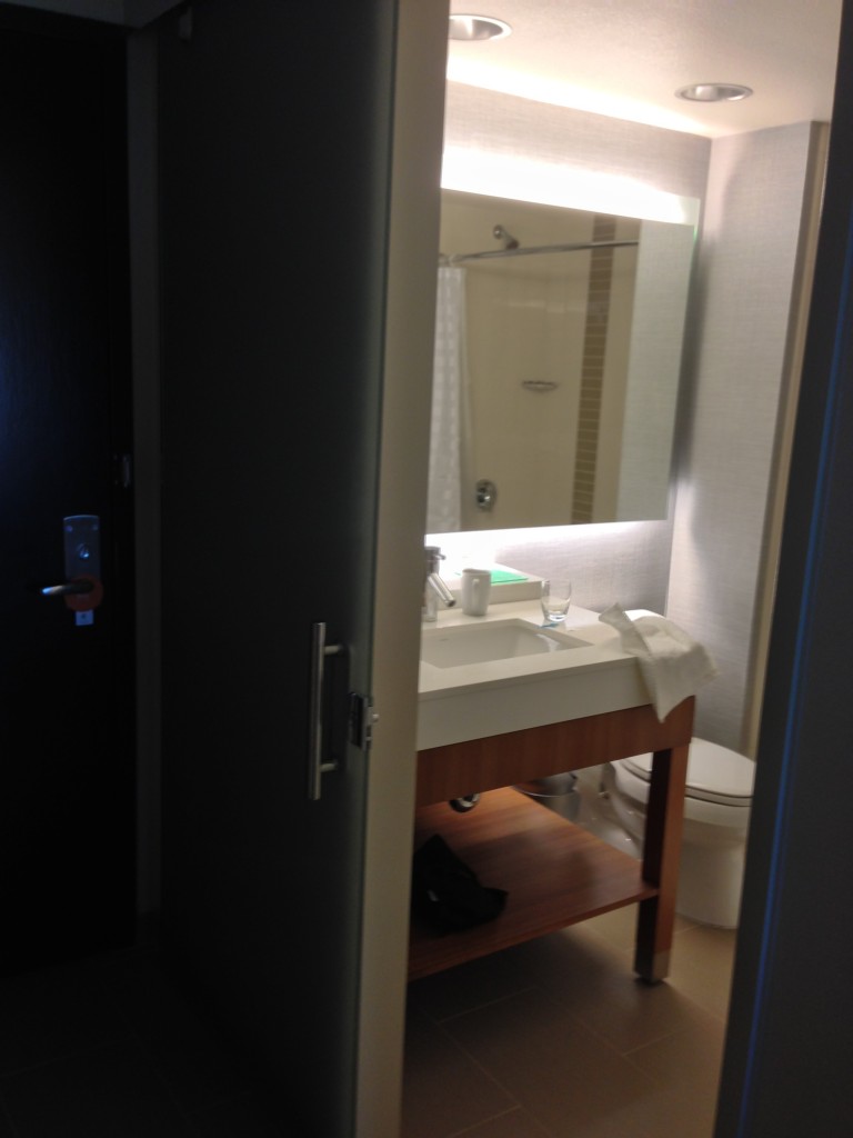 hyatt place bathroom with frosted glass sliding door and giant mirror