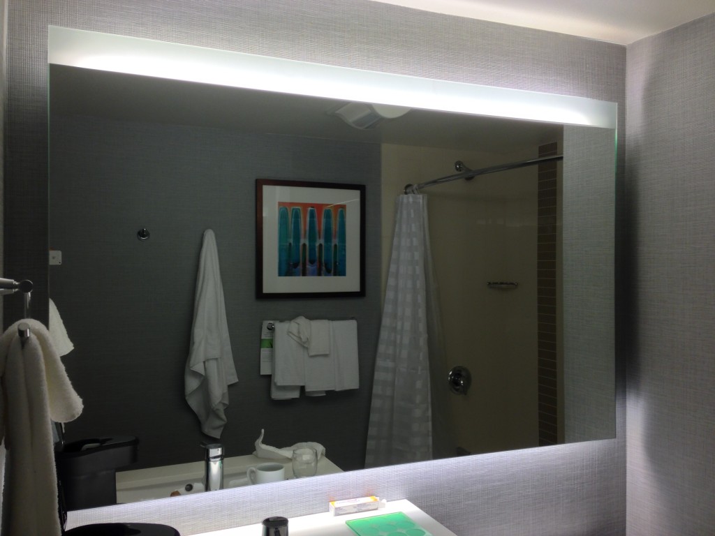 white glowing lights behind bathroom mirror at hyatt place
