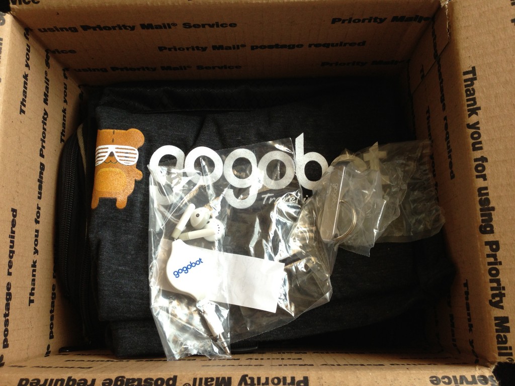 gogobot box of swag with (headphones, bottle opener keychain, t-shirt, and fancy toiletry bag