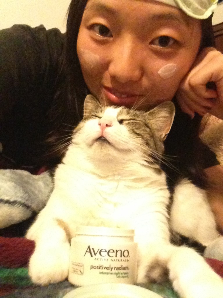 applying aveeno positively radiant night cream with cat