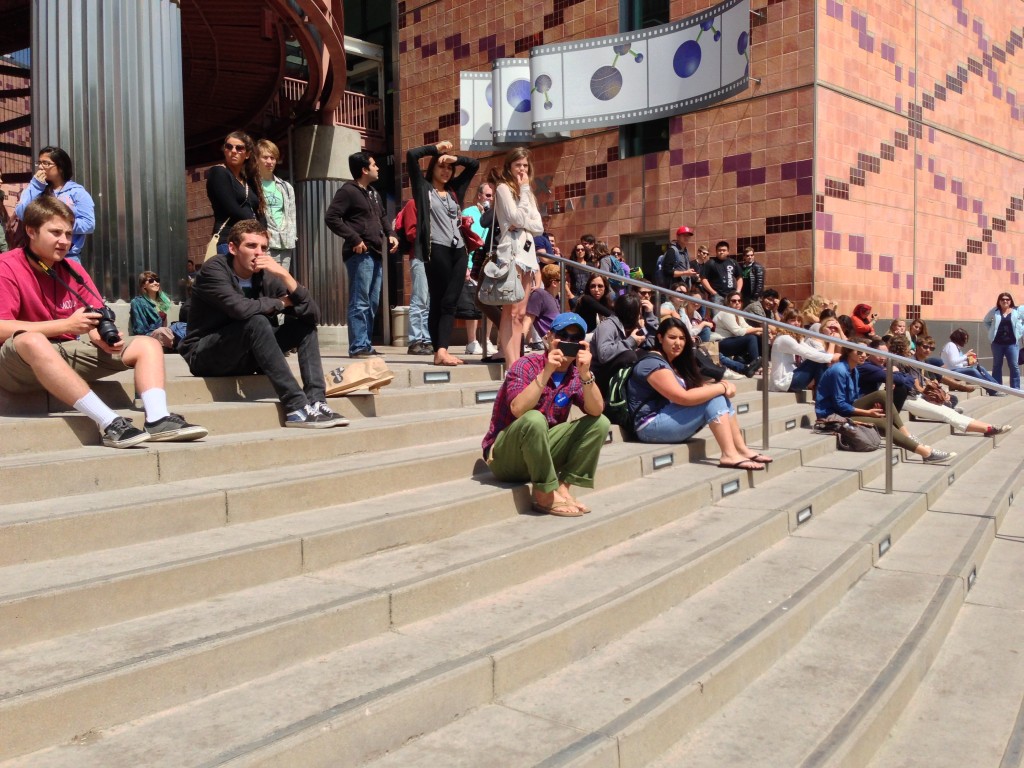 people sitting on stairs in front of california science center