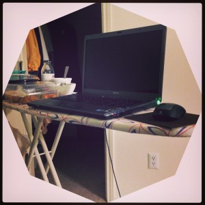 laptop sitting on ironing board used as desk