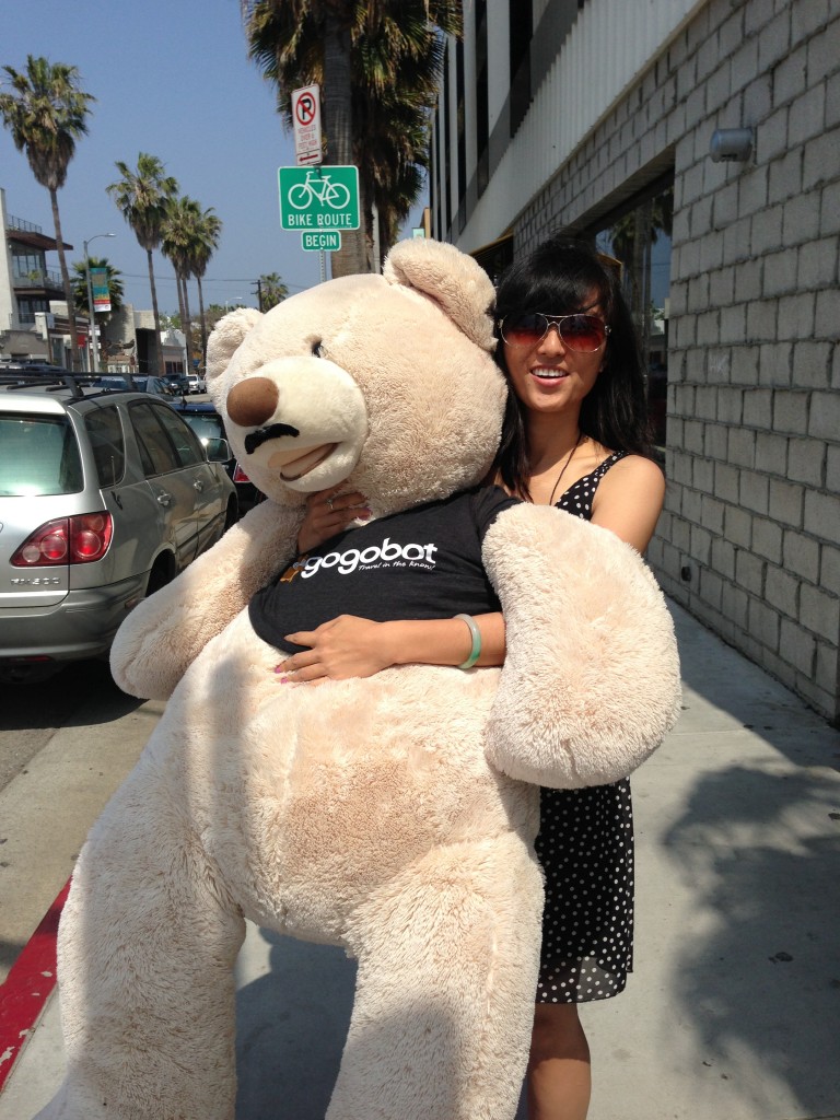 girl hugging giant teddy bear wearing gogobot tshirt