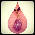 amethyst necklace held in hand with teardrop framing