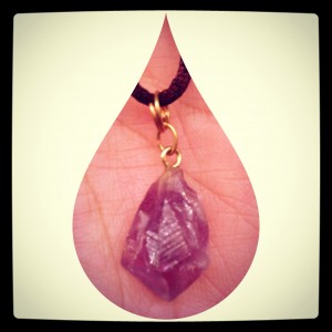 amethyst necklace held in hand with teardrop framing