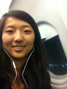 sitting on plane in window seat at night with earbuds in ears