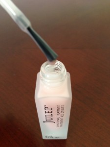 drop of julep oxygen nail treatment on brush hovering over bottle opening