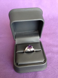 custom made engagement ring with purple sapphire center stone in black jewelry box