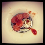 pile of coins in sink with hot sauce on top