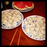 plates of homemade dumplings with watermelon in background