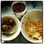 bowl of half-eaten ramen noodles, marinated mushrooms, and inko's tea drink