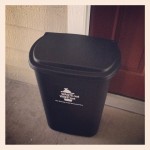black plastic trash bin outside apartment door