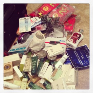 pile of products including soaps, travel shampoo and conditioners, lotions, socks, candles, lip balms, and gadgets