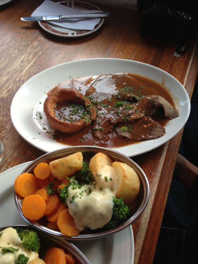 traditional british sunday roast with yorkshire pudding, roast beef and gravy, carrots, broccoli and cream, and potates