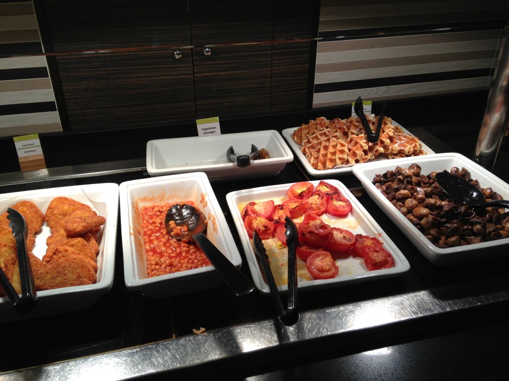 english breakfast buffet with hash browns, baked beans, roasted tomatoes, mushrooms, and waffles