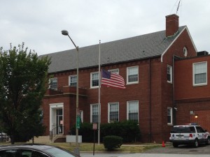 american flag billowing at half mast in front of police station