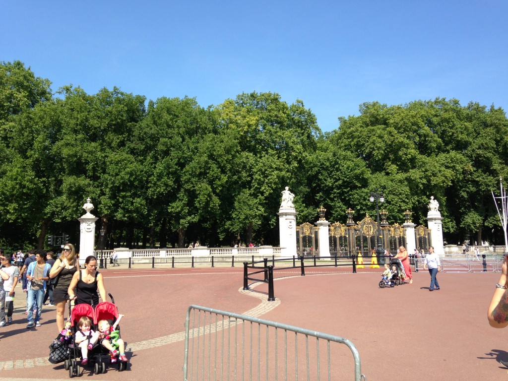 view of gates to green park and tourists walking around outside buckingham palace