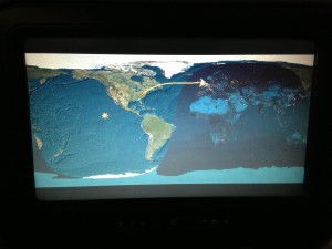 tv screen showing in flight map of plane flying from daylight into night