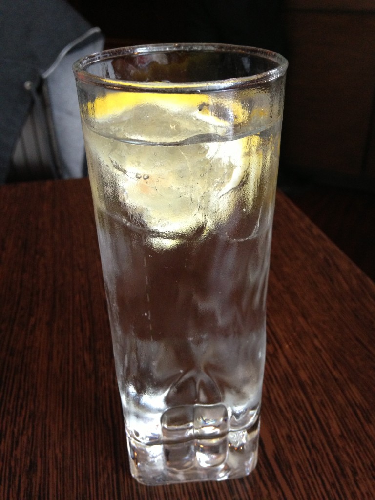 glass of clear sparkling lemonade drink with lemon slice inside