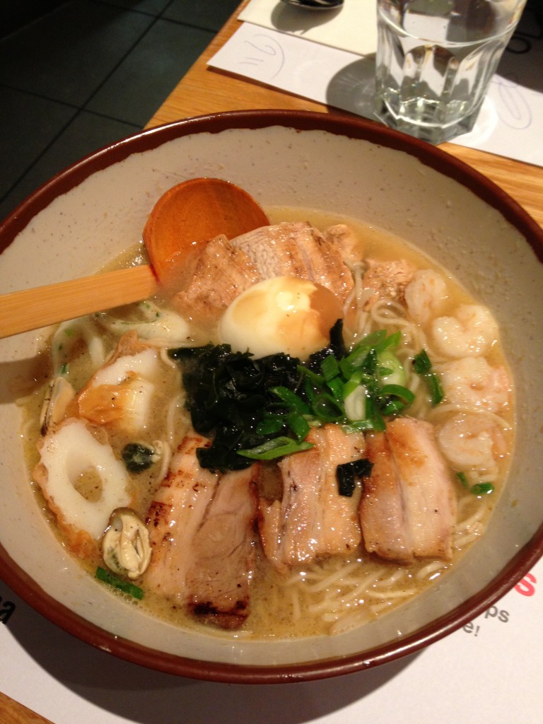 bowl of wagamama ramen dish with pork, shrimp, wakame seaweed, fish cakes, and tea egg
