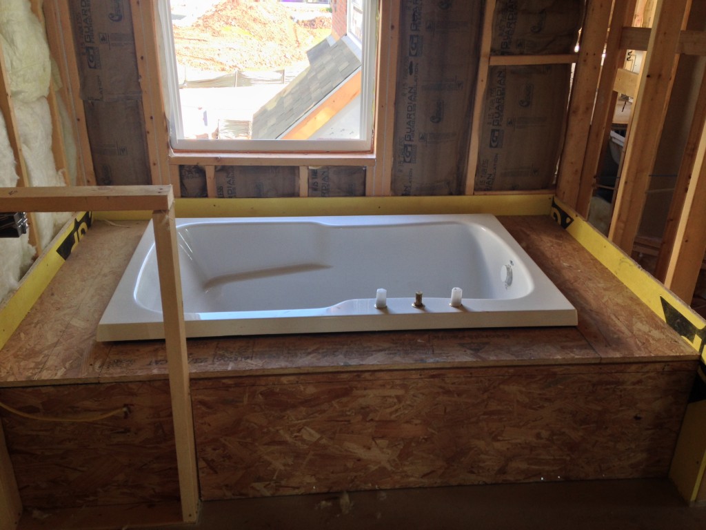 bathtub sitting in wooden framework of new condo being built