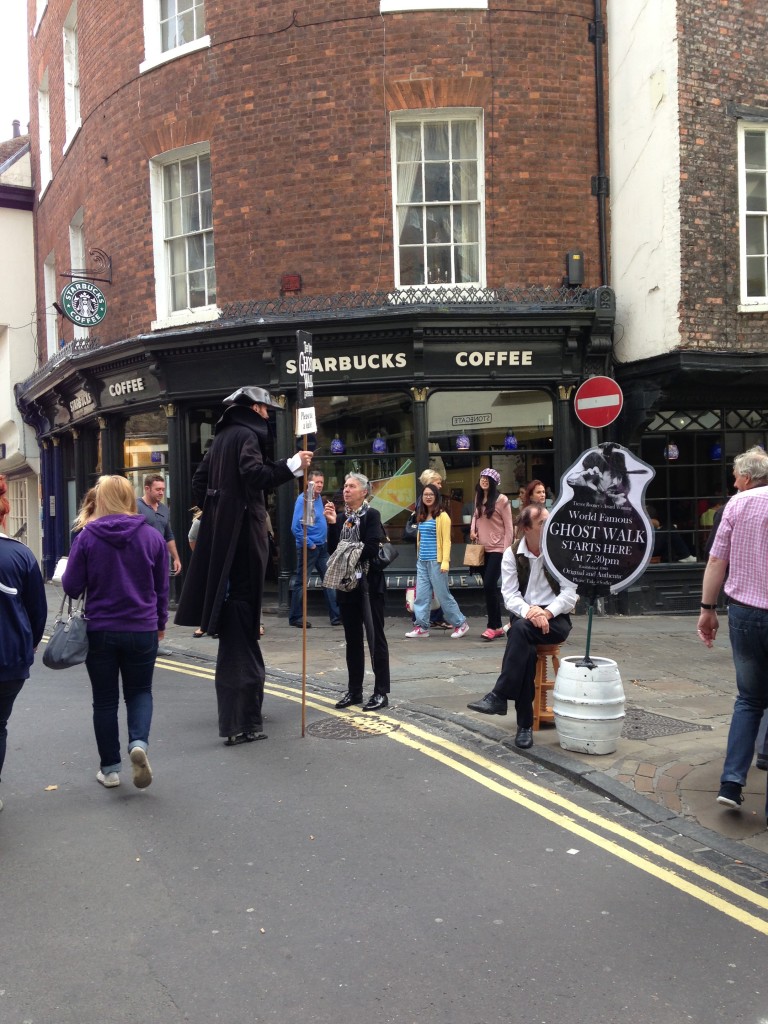 guy on stilts and man with ghost walk sign promoting york ghost walks