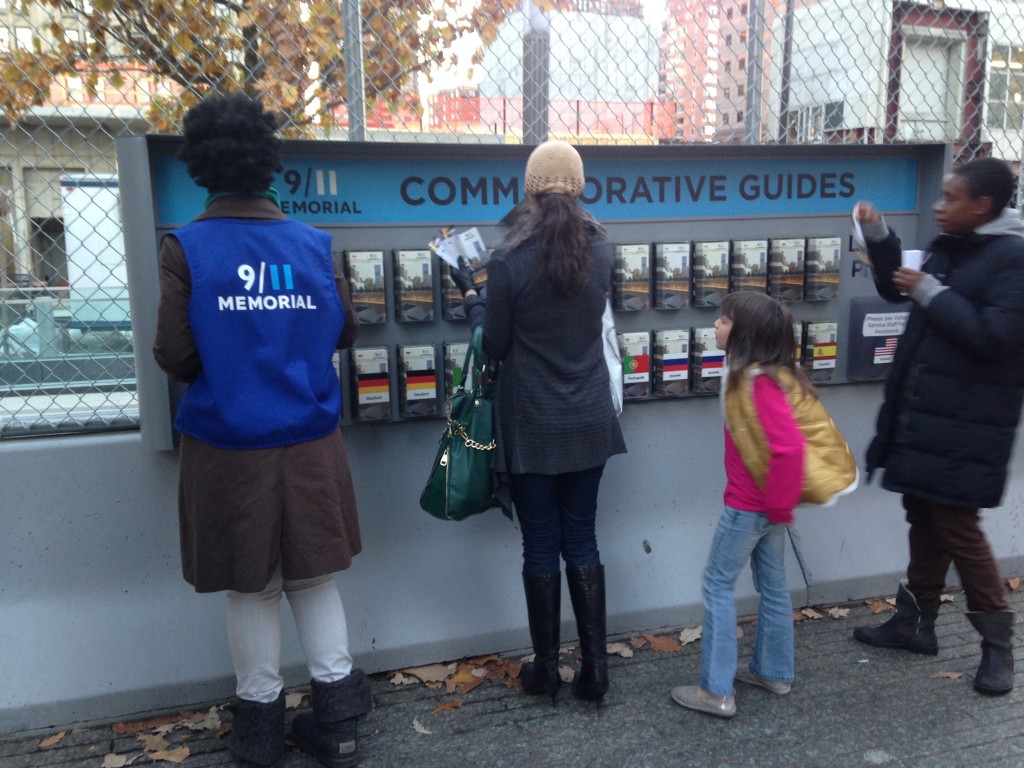 9/11 memorial commemorative guides with people browsing and worker replacing brochures