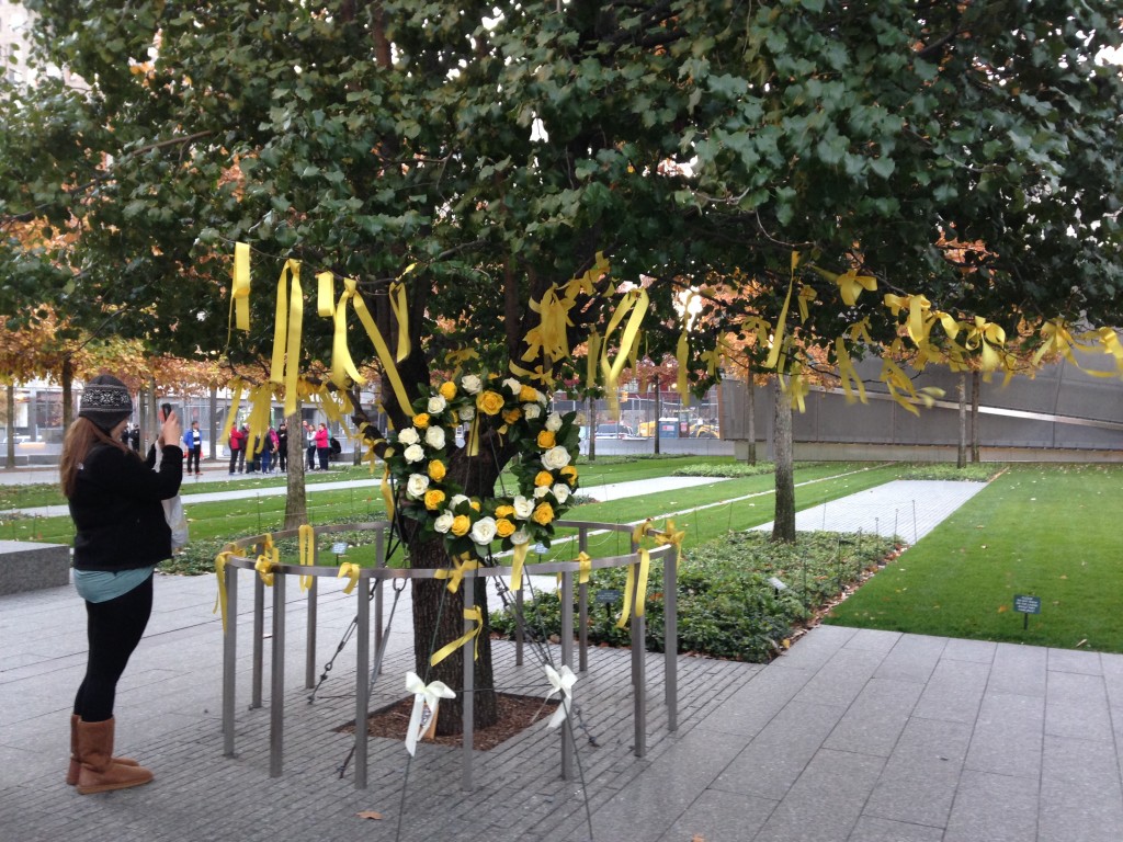 9/11 memorial tree with yellow ribbons and wreath with yellow and white flowers