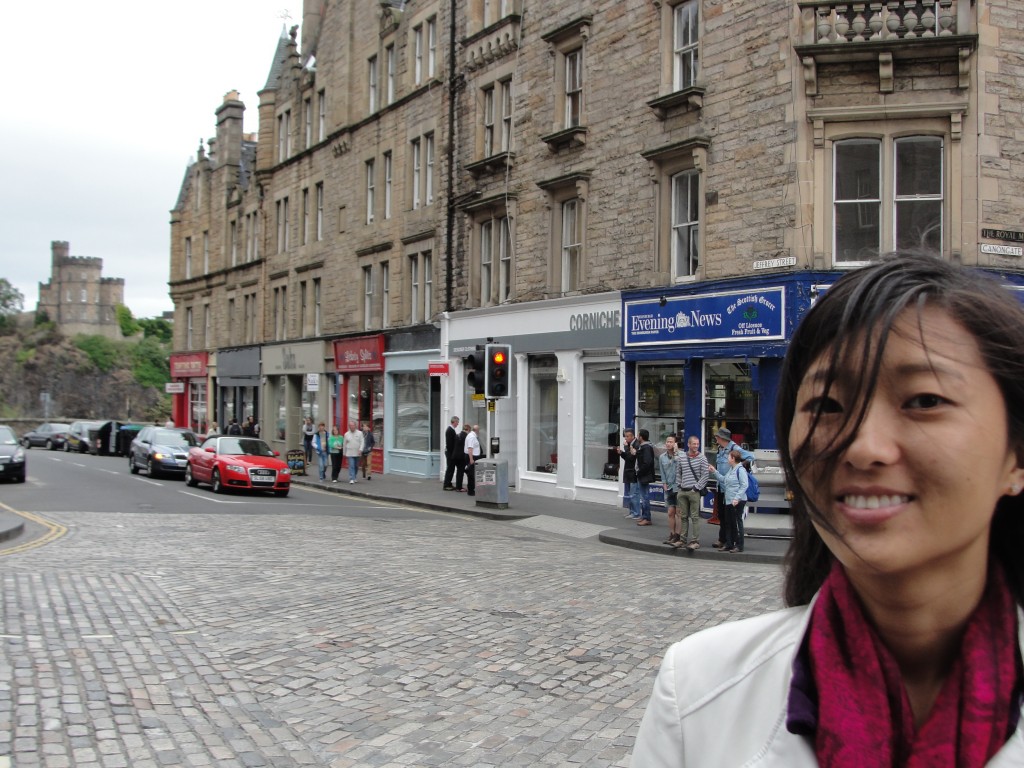 girl standing with hair blown in face on streets of edinburgh
